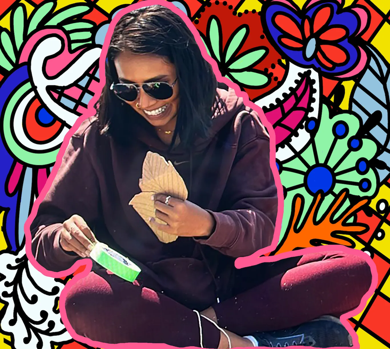 Fahmeeta sitting cross-legged in front of a colourful illustrated pattern